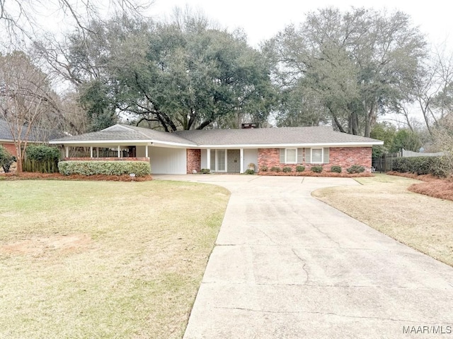 single story home with driveway, an attached carport, fence, a front lawn, and brick siding