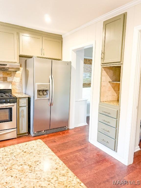 kitchen with stainless steel range with gas cooktop, ornamental molding, refrigerator with ice dispenser, light wood-type flooring, and under cabinet range hood