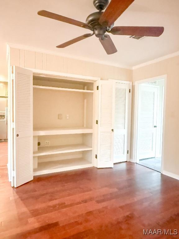 unfurnished bedroom with ornamental molding, a ceiling fan, and wood finished floors