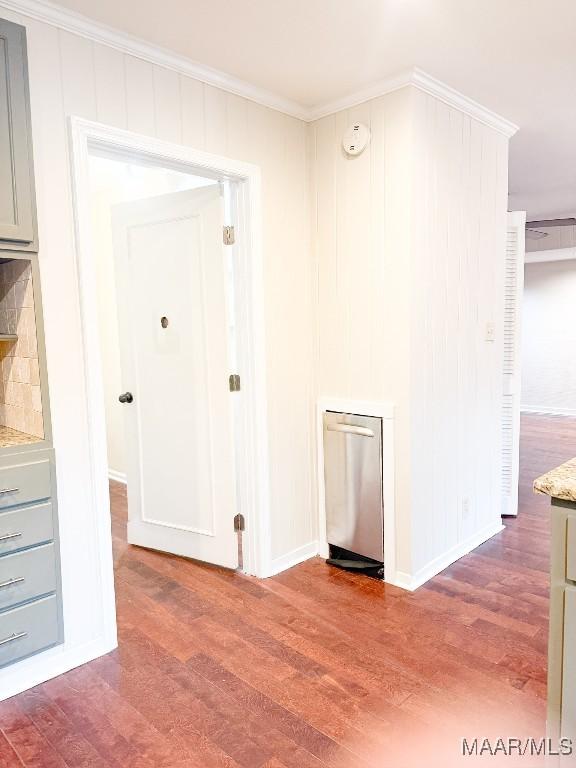 unfurnished room featuring ornamental molding, wood finished floors, and baseboards