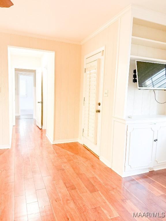 interior space featuring light wood-type flooring and crown molding