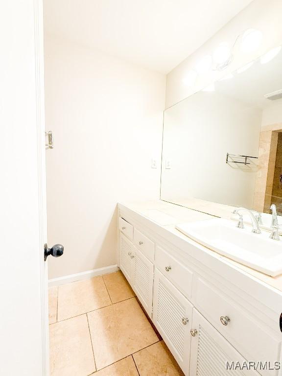 bathroom with visible vents, vanity, baseboards, and tile patterned floors