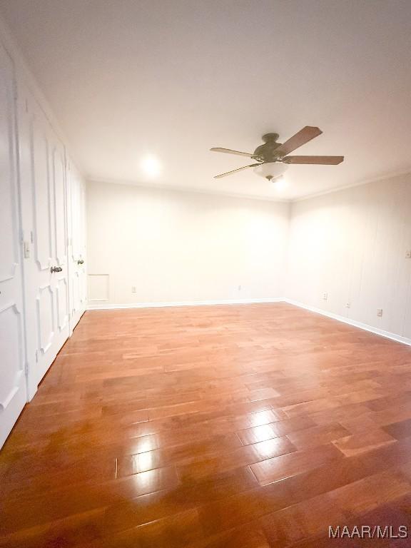 unfurnished room with a ceiling fan, light wood-type flooring, and baseboards