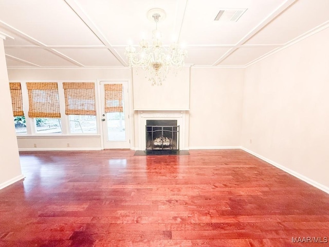 unfurnished living room with a notable chandelier, wood finished floors, a fireplace with flush hearth, visible vents, and baseboards