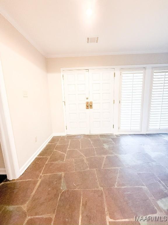 entryway featuring baseboards, visible vents, and stone tile floors