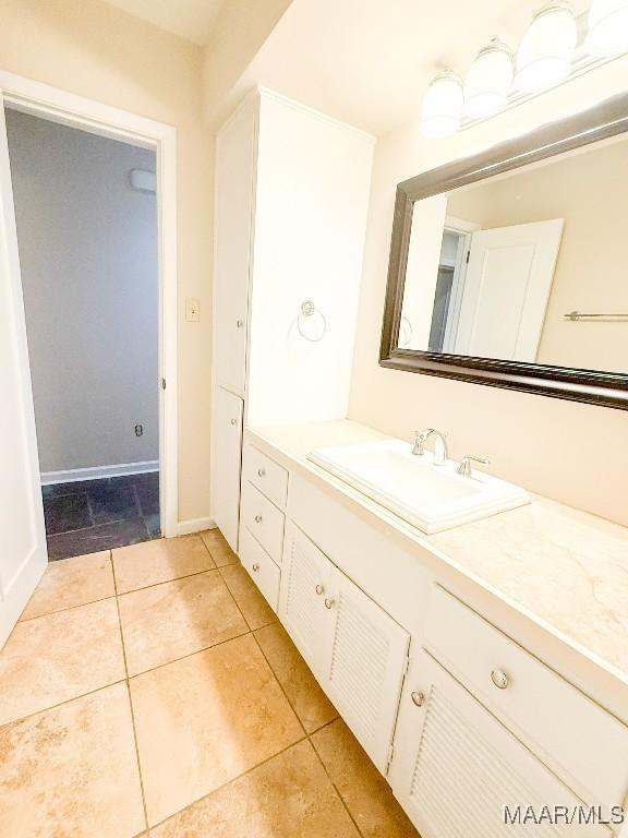 bathroom with baseboards, vanity, and tile patterned floors