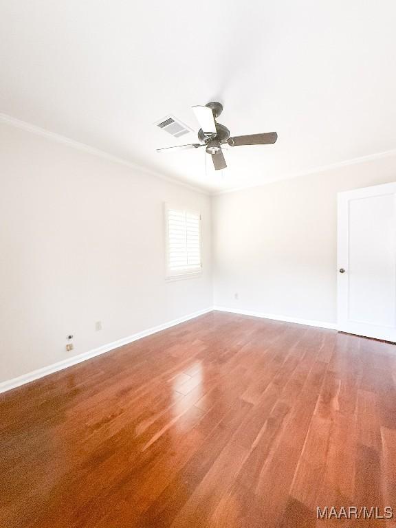 spare room featuring ornamental molding, visible vents, and light wood-style flooring