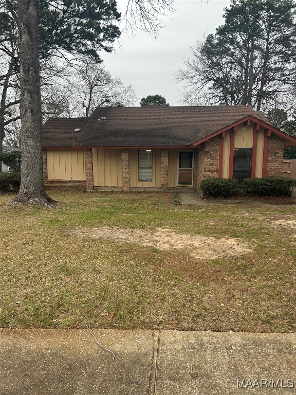 view of front of house with board and batten siding and a front lawn