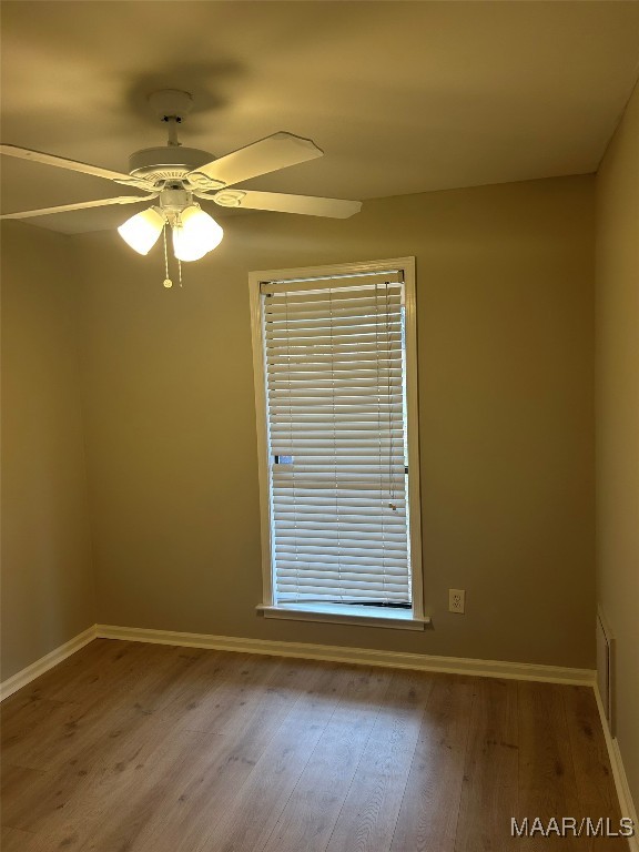 empty room featuring light wood-style flooring, baseboards, and a ceiling fan