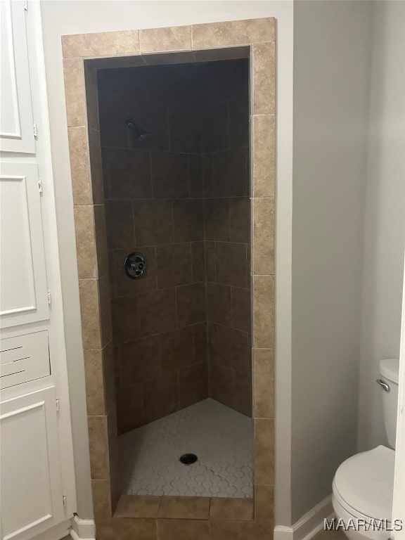 bathroom featuring baseboards, toilet, and walk in shower