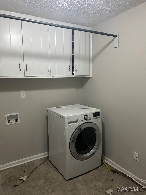 laundry room featuring washer / clothes dryer, cabinet space, a textured ceiling, and baseboards