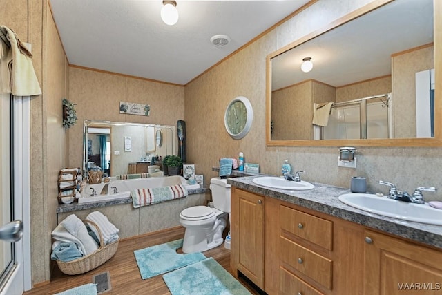 bathroom with a bath, ornamental molding, a sink, and wood finished floors