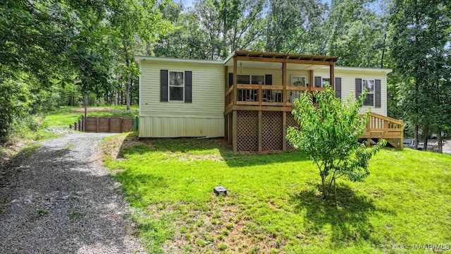 rear view of house featuring a yard and driveway