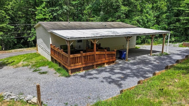 exterior space with metal roof, a carport, and driveway