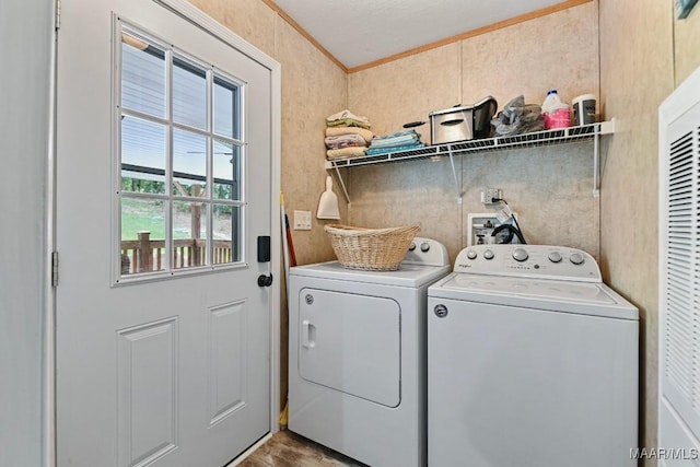 laundry area with laundry area, ornamental molding, and washer and clothes dryer