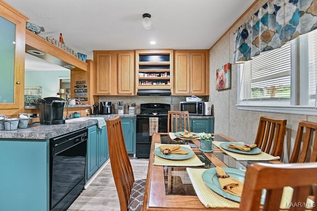 kitchen with light wood finished floors, a sink, range hood, black appliances, and backsplash