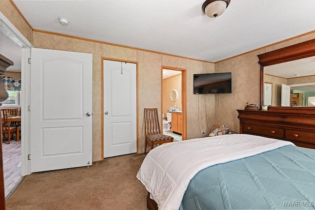 bedroom featuring ornamental molding, light carpet, and ensuite bathroom