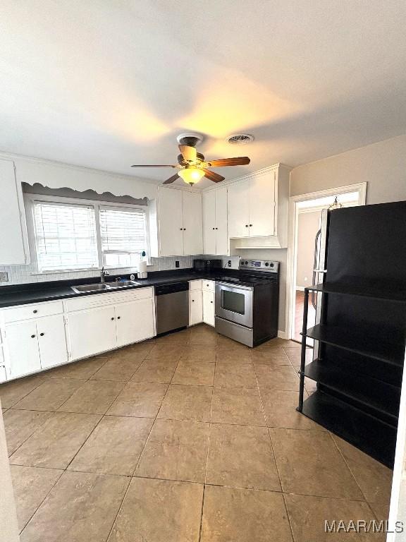 kitchen featuring dark countertops, visible vents, stainless steel appliances, and a sink