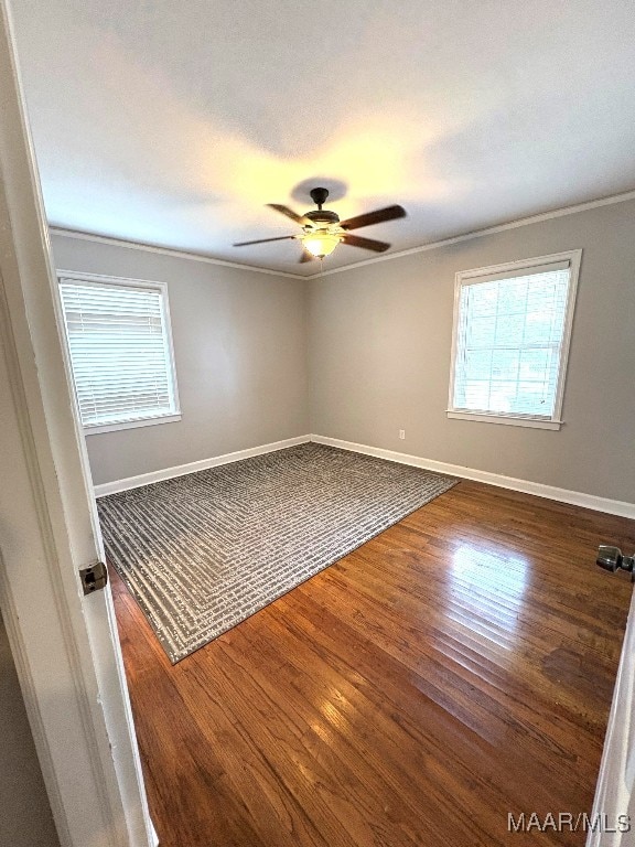 unfurnished room with a ceiling fan, baseboards, and wood finished floors