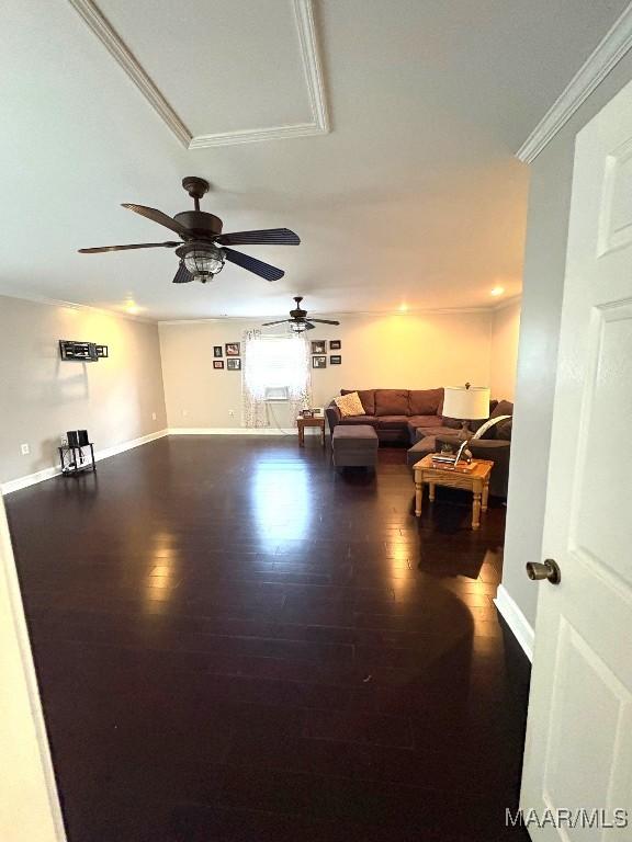 living area with baseboards, crown molding, and wood finished floors