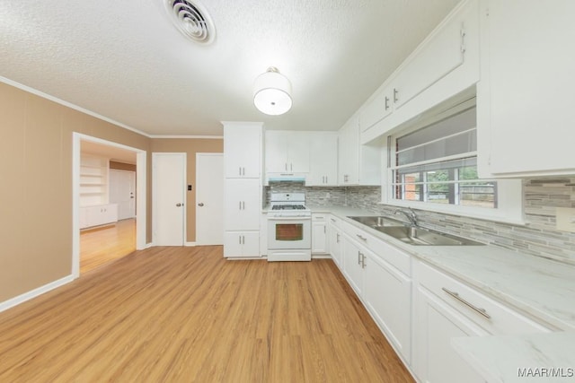 kitchen featuring visible vents, white gas stove, a sink, and white cabinetry