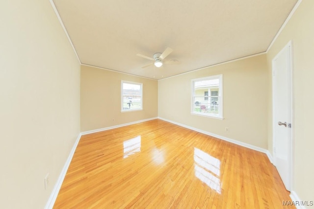 unfurnished room with ceiling fan, baseboards, crown molding, and wood finished floors