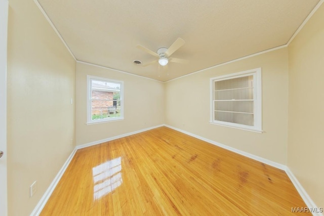 spare room with a ceiling fan, baseboards, ornamental molding, and wood finished floors