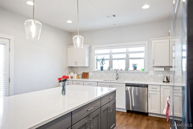 kitchen with light countertops, dishwasher, decorative light fixtures, and white cabinetry