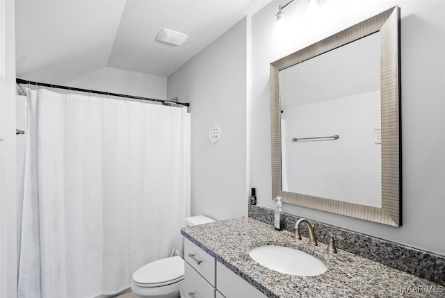 bathroom with vaulted ceiling, vanity, and toilet