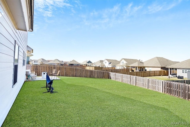 view of yard featuring a fenced backyard and a residential view