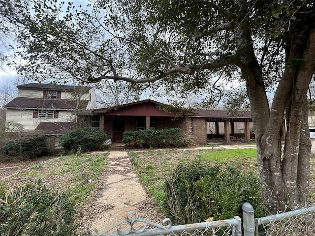 view of front facade with brick siding and fence