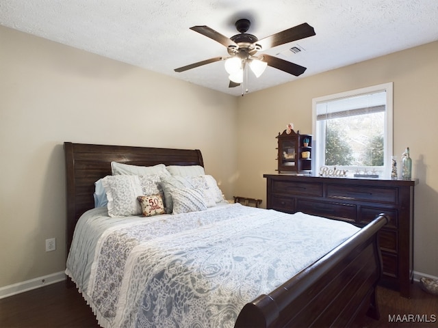 bedroom with visible vents, baseboards, ceiling fan, and dark wood-style flooring