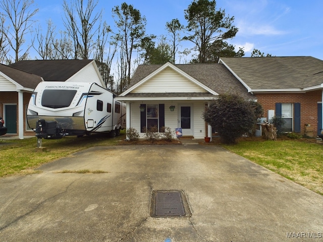 view of front of home with a porch, a front yard, and brick siding