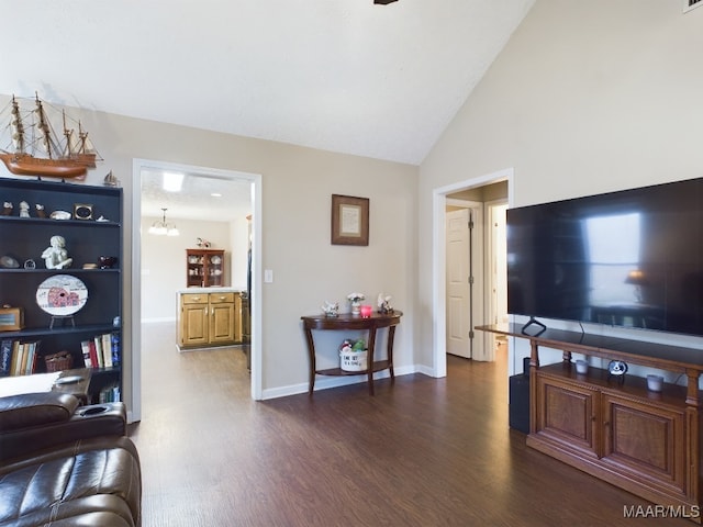 living room with lofted ceiling, an inviting chandelier, baseboards, and dark wood-style flooring