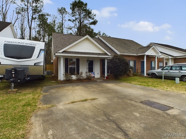 view of front of house featuring covered porch, a front lawn, and cooling unit