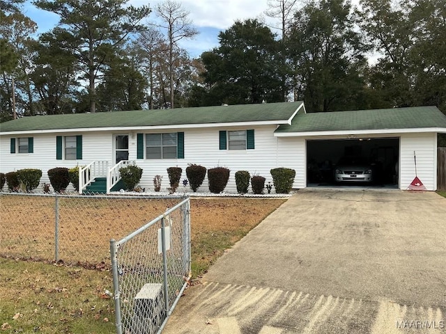 ranch-style home with driveway, a fenced front yard, and an attached garage