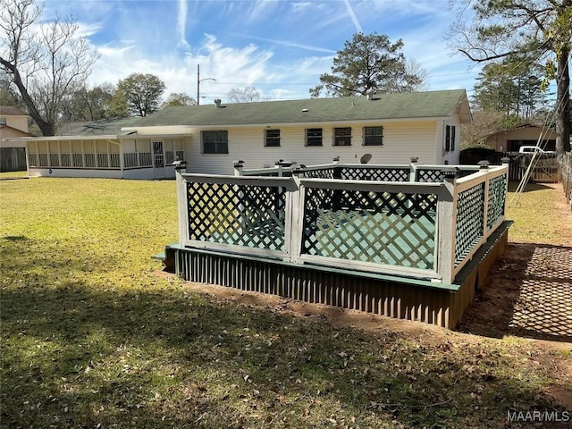 rear view of property with a sunroom and a lawn