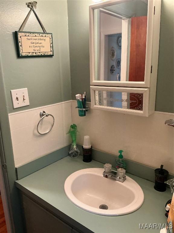 bathroom featuring a wainscoted wall and vanity