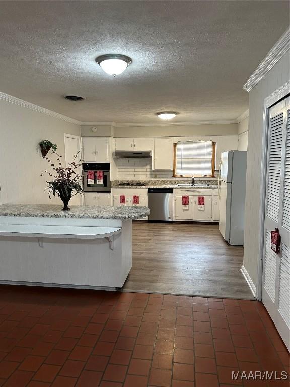 kitchen with white cabinets, under cabinet range hood, black appliances, and light stone countertops