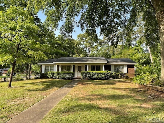 ranch-style house featuring a front lawn, fence, and brick siding