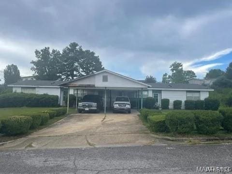 ranch-style home featuring an attached carport and driveway