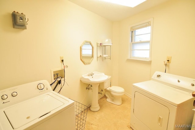 laundry room with laundry area, washing machine and clothes dryer, and baseboards