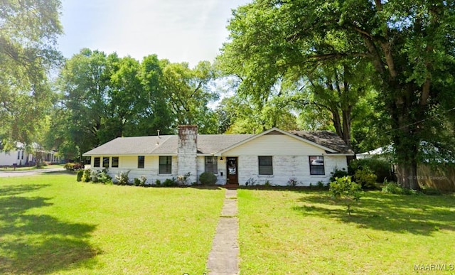 ranch-style home featuring a chimney and a front lawn