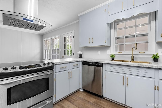 kitchen with appliances with stainless steel finishes, ornamental molding, dark wood-type flooring, light countertops, and a sink