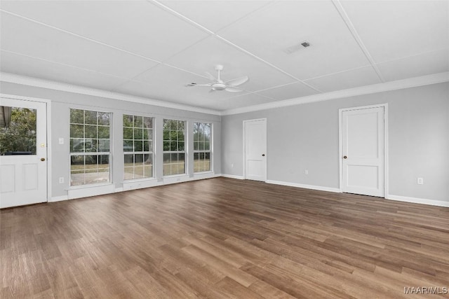 spare room featuring a ceiling fan, a healthy amount of sunlight, baseboards, and wood finished floors