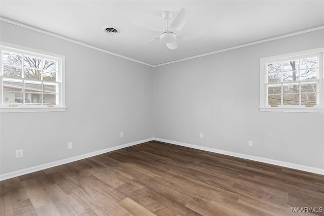 spare room with ornamental molding, dark wood-style flooring, visible vents, and ceiling fan