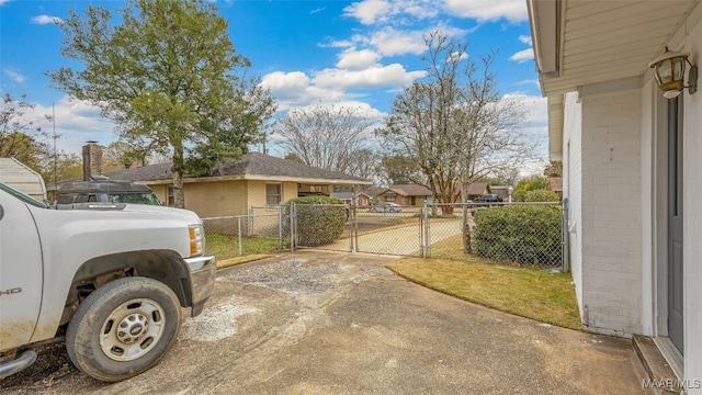 exterior space with a gate, a residential view, fence, and brick siding