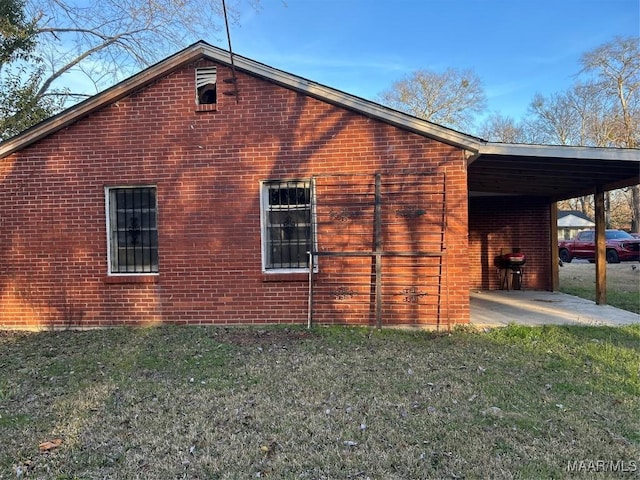 view of side of home featuring a lawn and brick siding