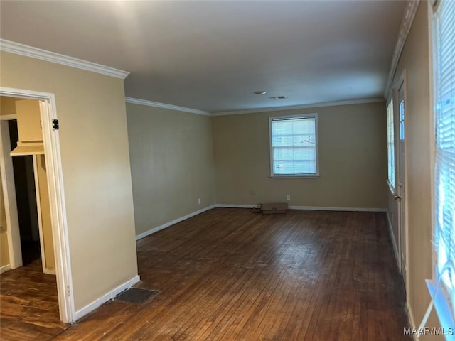 unfurnished room with dark wood-style floors, baseboards, visible vents, and crown molding