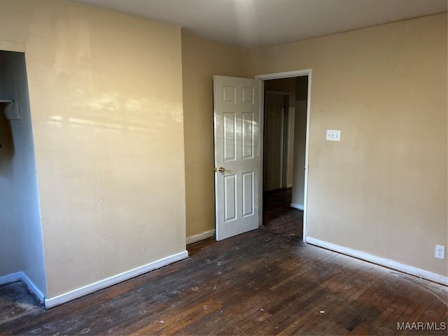 unfurnished room featuring dark wood finished floors and baseboards